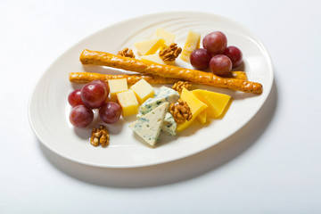 cheese and nuts, and grapes on the white plate