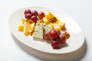 cheese and nuts, and grapes on the white plate