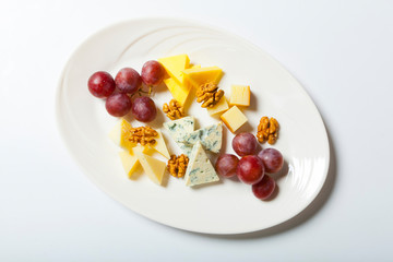 cheese and nuts, and grapes on the white plate