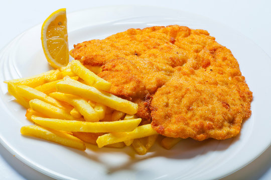 Viennese Schnitzel with fries on the white plate