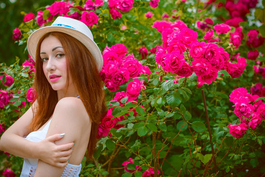 Beautiful and nice redhead woman in white hat in vacation spending a good time. Girl in white and pink light blue tones at clothes  