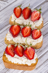 Sandwich of strawberry and cottage cheese on the wooden table, close up