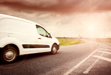 Obraz na płótnie Canvas asphalt road on with a small truck. van moving