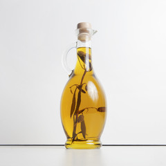 Olive oil in a glass jug. Olive branch inside pitcher