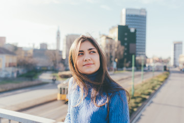 Portrait young woman outdoor back light looking away smiling - emancipation, freedom, girl power...