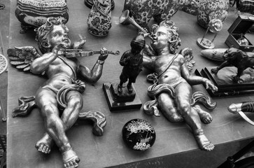 Flea market in Paris (France). Two golden baby angels playing on violin and trumpet. Retro style...