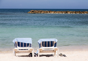 Two Chaise Lounges with Towels on Beach