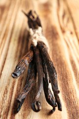 Dried vanilla sticks on wooden background, closeup