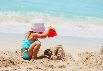 cute little girl play with sand on beach