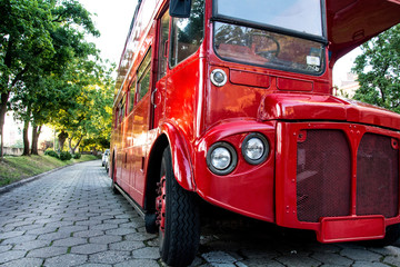 Red two-story English bus standing in the park on the waterfront