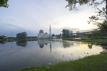 Rubbish pollution with plastic and other packaging stuffs on the lake with mosque background. Enviromental concept.