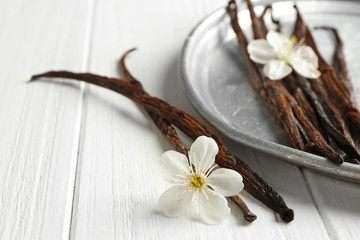 Composition with dried vanilla sticks on light wooden table, closeup