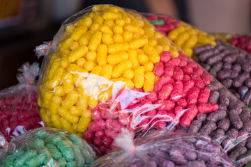 Feeding fish, colourful food for fish made from corn in a plastic bag, popular for feeding the fish in the temple or shrine.