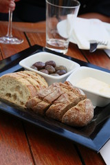 close up of a bread with olives on a wooden table