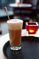 A glass latte macchiato in the cafe, the background with sharpening depth