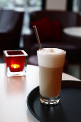 A glass latte macchiato in the cafe, the background with sharpening depth