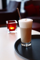 A glass latte macchiato in the cafe, the background with sharpening depth