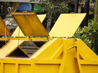 A large yellow trash container with opened hatches