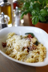 Pasta dish in an oval plate, in the restaurant on a wooden table
