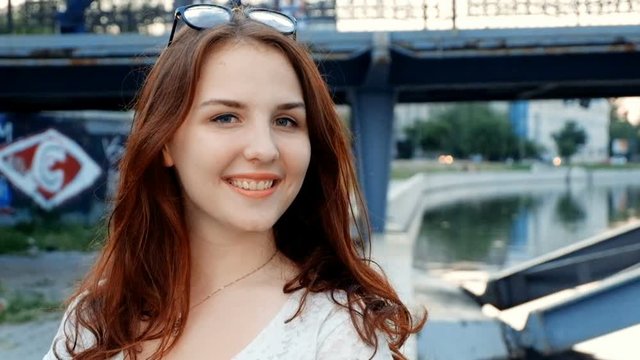 Young woman say hi for social media like vlog. Young redhead smiling happy in sunny outdoors