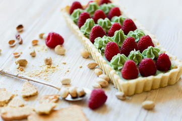 Pistachio tart. Pistachio tart on white Belgian chocolate BARRY with a layer of raspberry confit, crispy shortbread base, fading cream and juicy raspberries.A classic combination in miniature format.