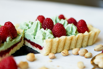 Pistachio tart. Pistachio tart on white Belgian chocolate BARRY with a layer of raspberry confit, crispy shortbread base, fading cream and juicy raspberries.A classic combination in miniature format.