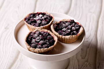 tartlets with lemon custard and blueberries on the white plate