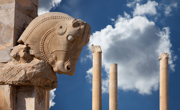 Persian Column with Bull Capital Against Blue Sky with White Fluffy Clouds from Persepolis of Shiraz in Iran