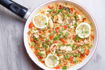 Paella with chicken, tomatoes and pepper . Traditional Spanish dish. Selective focus