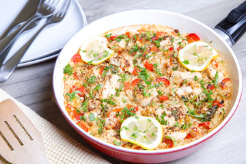 Paella with chicken, tomatoes and pepper . Traditional Spanish dish. Selective focus
