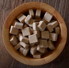 Brown sugar cubes in bowl. Top view