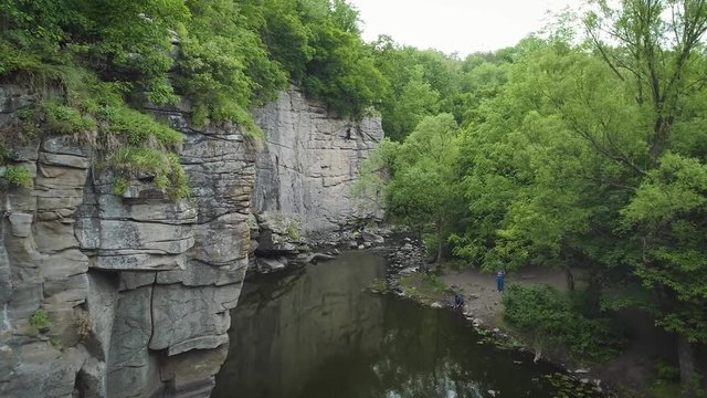 Aerial footage. Fly in canyon. Zoom out climber on rock wall