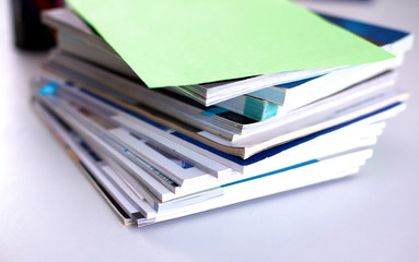 A stack of documentation is on the desktop in the office