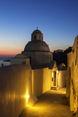 Narrow street in Fira town at sunset with the Orthodox Greek Church, Santorini, Greece