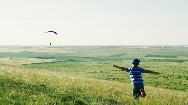 The boy runs his arms like wings