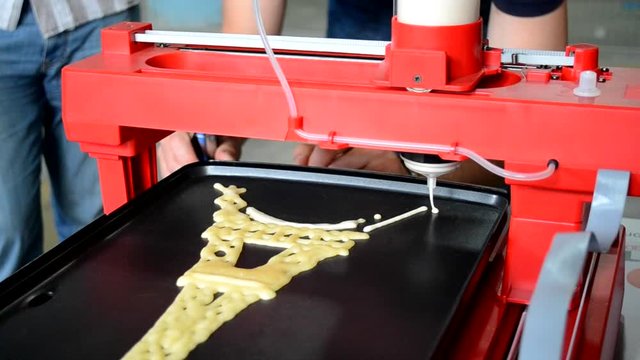 3d printer for liquid test. 3D printer printing pancakes with liquid dough different shapes close-up. Modern additive technologies 4.0 industrial revolution
