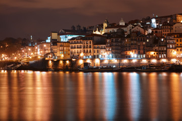 Fototapeta premium Ribeira and Old town of Porto with mirror reflections in the Douro River at night, Portugal, Portugal.