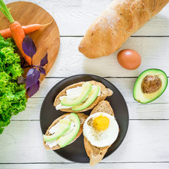 Sandwich with avocado and egg on white table. Flat lay. Top view.