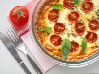 Rustic pie with vegetables and cheese. French quiche. Vegetarian tart with spinach, ricotta and cherry tomatoes. Top view.