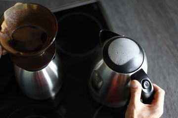 Close up of male hands that prepare a delicious coffee with naturally colors in soft-focus in the background.