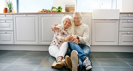 Happy couple sitting on kitchen floor