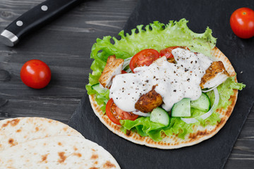 Preparing mexican fajita wrap with chicken meat and vegetables