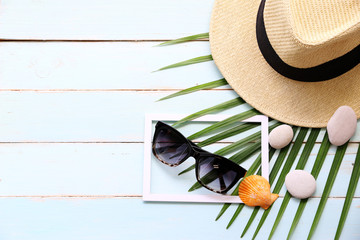 welcome summer with hats,Sunscreen,coconut leaves and Shell on the blue table background