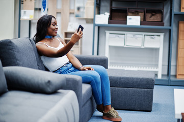 Obraz premium Portrait of a beautiful african american woman taking a selfie in the shop.