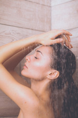 Young beautyful woman under shower in bathroom.