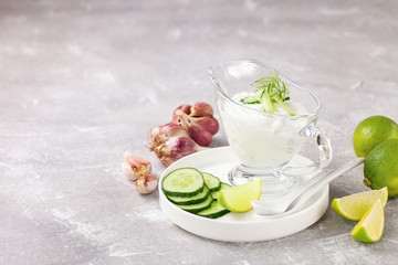 Tzatziki sauce in a glass sauce-boat. Ingredients for a dzadziki. Turkish dish cacik. Selective focus. Copy space