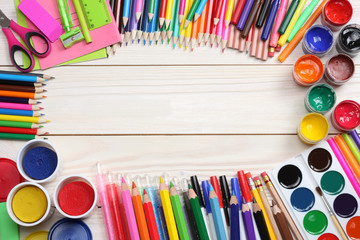 school background. colored pencils, pen, pains, paper for  school and student education on wood background. top view with copy space