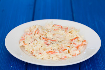 cabbage salad on white plate on wooden background