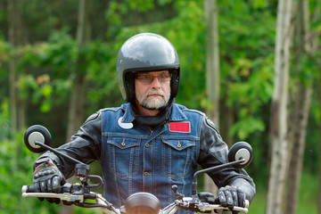 Portrait of one motorcyclist male in glasses and grey helmet