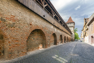 View of the famous Cetatii Road and Potters Tower in the historic center of Sibiu, Romania, with the ancient city walls